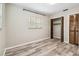 Bright bedroom features gray wood-look floors, window, and closet with paneled doors at 2701 W Osborne Ave, Tampa, FL 33614