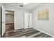 This bedroom features wood-look floors, a large window, and a built in closet with mirrors at 2701 W Osborne Ave, Tampa, FL 33614