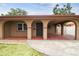 Exterior of a home featuring a covered carport with arched entryways and terracotta flooring at 2701 W Osborne Ave, Tampa, FL 33614