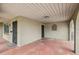 Exterior covered carport featuring terracotta flooring, arched entryways, and a glimpse of the outdoors at 2701 W Osborne Ave, Tampa, FL 33614