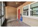 Enclosed porch with brick pavers, ceiling fan, view to the backyard and a red exterior door at 2701 W Osborne Ave, Tampa, FL 33614
