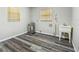 Utility room featuring wood-look floors, two windows, and a white utility sink with a water heater at 2701 W Osborne Ave, Tampa, FL 33614