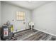 Utility room featuring wood-look floors, one window, and a white utility sink with a water heater at 2701 W Osborne Ave, Tampa, FL 33614