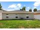 The backyard features an air conditioning unit, a well-maintained lawn, and a gray house exterior at 2906 E Columbus Dr, Tampa, FL 33605