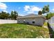 Cozy backyard featuring a lawn and an air conditioning unit, enclosed by a pristine white fence at 2906 E Columbus Dr, Tampa, FL 33605