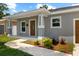 Inviting covered porch with decorative columns and a beautifully landscaped garden at 2906 E Columbus Dr, Tampa, FL 33605