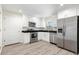 Modern kitchen featuring stainless steel appliances, white cabinetry, and black countertops at 2906 E Columbus Dr, Tampa, FL 33605