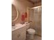 Cozy bathroom with a standalone shower behind glass, mirror, and a white sink and toilet at 2910 Star Apple Ct, Palm Harbor, FL 34684