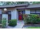 Close-up of the front entrance showcasing the bright red door and manicured landscaping at 2910 Star Apple Ct, Palm Harbor, FL 34684
