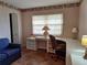 Small office area featuring a built-in desk next to a large window and a comfortable blue sofa at 2910 Star Apple Ct, Palm Harbor, FL 34684