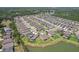 Aerial view of new homes in a lakeside community showcasing pools, landscaping, and serene water views that offer the perfect setting at 30214 Skylark Dr, Wesley Chapel, FL 33545
