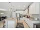 Bright kitchen featuring white cabinetry, stainless steel appliances, and a large island with granite countertops at 30214 Skylark Dr, Wesley Chapel, FL 33545