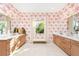Charming bathroom featuring double vanities, vibrant wallpaper, and a window allowing natural light at 32249 Tribeca Ave, Wesley Chapel, FL 33543