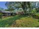 Lush backyard features mature trees, green lawn, and garden beds providing a private and serene outdoor space at 3416 W Morrison Ave, Tampa, FL 33629
