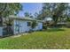 Side yard showing green lawn, landscaping, and a section of the home's exterior at 3416 W Morrison Ave, Tampa, FL 33629