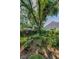 Lush backyard features mature trees, green lawn, and garden beds providing a private and serene outdoor space at 3416 W Morrison Ave, Tampa, FL 33629