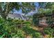 Lush backyard features mature trees, green lawn, and brick patio providing a private and serene outdoor space at 3416 W Morrison Ave, Tampa, FL 33629