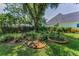 Lush backyard features mature trees, green lawn, and garden beds providing a private and serene outdoor space at 3416 W Morrison Ave, Tampa, FL 33629