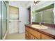 Bathroom featuring a shower with glass sliding doors and a vanity with ample storage at 3416 W Morrison Ave, Tampa, FL 33629