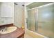 Bathroom with a single sink, shower with glass sliding doors, and decorative wallpaper at 3416 W Morrison Ave, Tampa, FL 33629