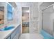 Bathroom featuring blue fixtures, floral wallpaper, and a view into the bedroom at 3416 W Morrison Ave, Tampa, FL 33629