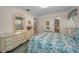 Well-lit bedroom with floral bedding, a decorative dresser, and a vanity area at 3416 W Morrison Ave, Tampa, FL 33629