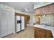 Eat-in kitchen with wood cabinetry, a white refrigerator, and a view to the dining room at 3416 W Morrison Ave, Tampa, FL 33629