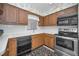 Bright kitchen featuring stainless steel appliances, wood cabinetry, and a white tile backsplash at 3416 W Morrison Ave, Tampa, FL 33629