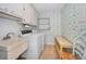 Laundry room with a utility sink, washer and dryer, storage cabinets, and floral wallpaper at 3416 W Morrison Ave, Tampa, FL 33629