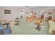 Open-concept living room with classic furnishings, vintage green carpet, and multiple seating areas at 3416 W Morrison Ave, Tampa, FL 33629