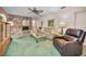 Inviting living room featuring a brick fireplace, comfortable seating, and plush green carpeting at 3416 W Morrison Ave, Tampa, FL 33629