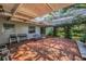 Brick patio with wrought iron table and chairs, a trellis overhead, and shade at 3416 W Morrison Ave, Tampa, FL 33629