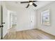 Bright bedroom with wood-look flooring, ceiling fan, window and white trim at 3535 16Th N St, St Petersburg, FL 33704