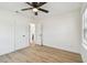 This bedroom has a ceiling fan, light wood floors, white walls, and two doors at 3535 16Th N St, St Petersburg, FL 33704