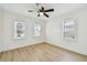 Bedroom featuring wood-look flooring, three windows and ceiling fan at 3535 16Th N St, St Petersburg, FL 33704
