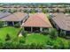 An aerial view showcases this home's tile roof, screened-in lanai, and well-manicured backyard at 4165 San Severo Rd, Wesley Chapel, FL 33543