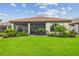 A verdant lawn and colorful flower beds accent the cozy screened-in lanai of this inviting home at 4165 San Severo Rd, Wesley Chapel, FL 33543