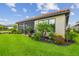 Landscaped backyard featuring lush green lawn, tropical plants, and privacy at 4165 San Severo Rd, Wesley Chapel, FL 33543