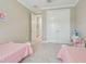 Bright bedroom with two toddler beds, closet, and neutral walls at 4165 San Severo Rd, Wesley Chapel, FL 33543