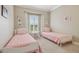 Neat bedroom featuring twin beds, neutral walls, and a bright window with plantation shutters at 4165 San Severo Rd, Wesley Chapel, FL 33543