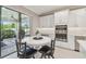 Bright eat-in kitchen features white cabinetry, stainless steel appliances, and sliding door access to the lanai at 4165 San Severo Rd, Wesley Chapel, FL 33543