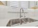 Stainless steel kitchen sink with modern faucet and white backsplash and shutters at 4165 San Severo Rd, Wesley Chapel, FL 33543