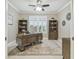 Bright office featuring custom built-ins, plantation shutters, and a ceiling fan at 4165 San Severo Rd, Wesley Chapel, FL 33543