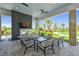 Cozy outdoor patio area with fireplace, comfortable seating, and a view of lush greenery at 4165 San Severo Rd, Wesley Chapel, FL 33543