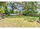 Spacious backyard featuring a well-maintained lawn, mature trees, and established landscaping at 417 Broadway, Dunedin, FL 34698