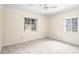 Bright bedroom with neutral walls, plush carpeting, and natural light from large windows at 417 Broadway, Dunedin, FL 34698