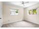 Cozy bedroom with plush carpeting, neutral walls, a ceiling fan, and natural light from large windows at 417 Broadway, Dunedin, FL 34698