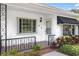 Close up of the home's front entrance with brick floor, decorative metal railing, and number 417 on wall at 417 Broadway, Dunedin, FL 34698