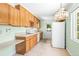 Functional kitchen with light green walls, wooden cabinetry, and adjacent breakfast nook area at 417 Broadway, Dunedin, FL 34698