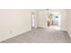 Spacious living room with neutral carpet, light colored walls, and a doorway to the kitchen area at 417 Broadway, Dunedin, FL 34698